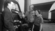 Robert Gard visits with farmers on May 9, 1955. Gard traveled across the state (note the Wisconsin Idea Theater logo painted on the side of his truck) to promote and cultivate the theatrical arts in rural communities. Gard was a well-known figure in Wisconsin through his travels as well as his WHA-Radio program, and later WHA-TV program, “Wisconsin Is My Doorstep.”  UW Digital Collections/ID S15183