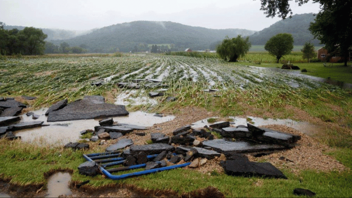 Rushing flood waters carried off large pieces of asphalt and a gate near Glen Marshall Farm on Hwy P in Spring Coulee. Photo by Jon Lee.