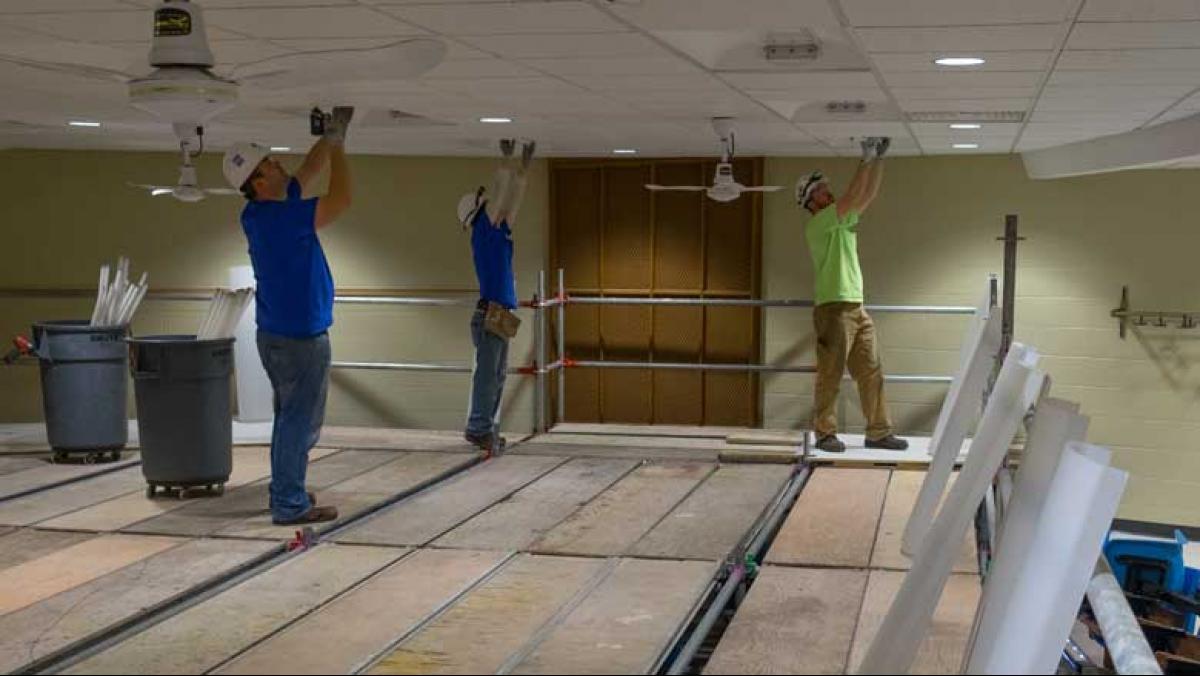 Energy conservation measures under way at UW–Stevens Point include upgrading lights to energy efficient LED lights. Here (l to r), Andy Klessig, Jose Rodriguez and Patrick Houlihan of Faith Technologies replace lighting in a Science Building lecture hall.