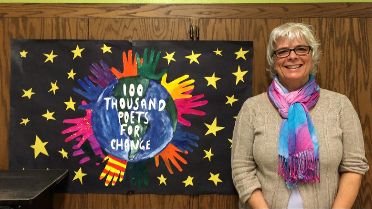 Author Lisa Vihos at I.D.E.A.S. Academy with the poster made by high school students in Stuart Howland’s graphic design class. 