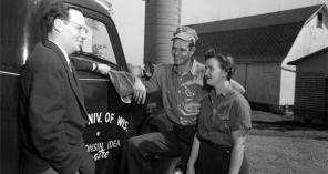 Robert Gard visits with farmers on May 9, 1955. Gard traveled across the state (note the Wisconsin Idea Theater logo painted on the side of his truck) to promote and cultivate the theatrical arts in rural communities. Gard was a well-known figure in Wisconsin through his travels as well as his WHA-Radio program, and later WHA-TV program, “Wisconsin Is My Doorstep.”  UW Digital Collections/ID S15183