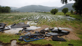 Rushing flood waters carried off large pieces of asphalt and a gate near Glen Marshall Farm on Hwy P in Spring Coulee. Photo by Jon Lee.