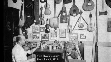 Otto Rindlisbacher, folk singer and maker of stringed instruments, sitting in his shop holding a Hardanger fiddle. Photo ca. 1941 by folklorist Helene Stratman-Thomas. Reprinted by permission of the Wisconsin Historical Society (WHS: #25413).